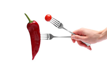 Fototapeta na wymiar Close up female hand holds fresh red pepper and cherry tomato on forks isolated on white background. Proper nutrition, vegetarian food, healthy lifestyle, vegetable concept.