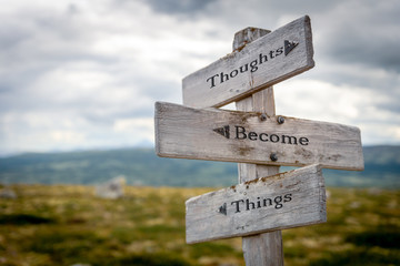 thoughts become things text engraved on old wooden signpost outdoors in nature. Quotes, words and illustration concept. - obrazy, fototapety, plakaty