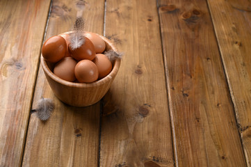rustic eggs, from homemade chickens, on a wooden background, with feathers. Eco foods, clean food. Vintage photo. The concept of natural food. Copy space