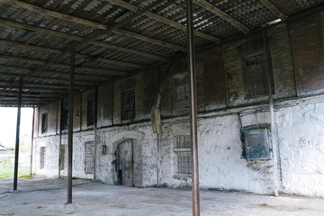Old abandoned brick mill. White wall in old mill with wood roof. Stock for grains. Historical...