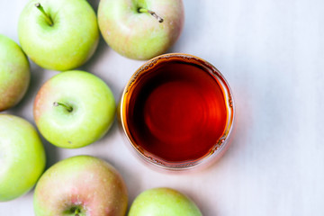 glass of apple juice to green apples. Close-up. selective focus on a white background, text space, copy space