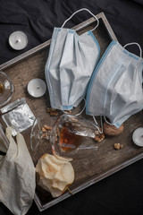 Sex during the coronavirus pandemic. Two medical masks and a condom wrappera wooden tray and a black sheet. COVID19 concept