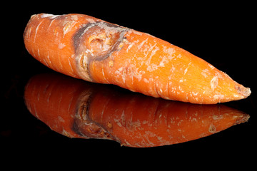 Rotting carrots on a black background - 348241903