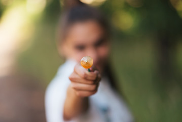 The girl shows the candy on a stick in the frame.
