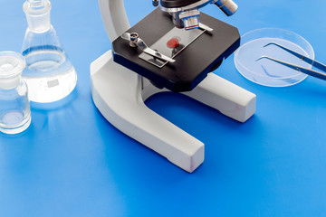 Microscope medical reserch. Blood sample for analysis. Blue table copy space