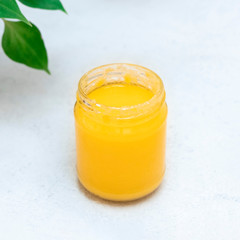 Gut-healthy, energy boosting jar of ghee butter on neutral background, copy space