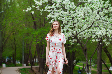 Portrait of a young beautiful blonde woman in a white dress