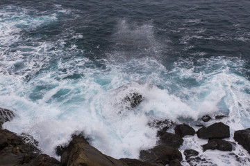 Stormy sea. Wave splash. The wave beats on the shore. Sea spray and foam around the stone. Water...