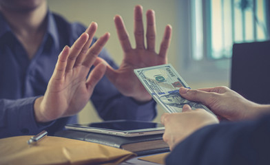 Businessmen give dollars to bribe employees in signing contracts to buy illegal land and real estate, Business fraud and social injustice, Anti Bribery and corruption concept,