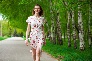 Portrait of a young beautiful blonde woman in white flowers dress