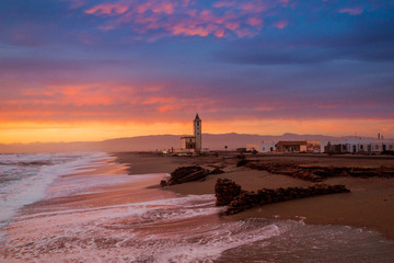 Red-clouded sunset view on Las Salinas beach with San Miguel church in the background at Cabo de Gata-Níjar Natural Park, Almería, Andalusia, Spain © inigolaitxu