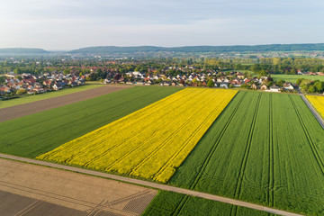 Luftaufnahme von Feldern mit einer Kleinstadt im Hintergrund