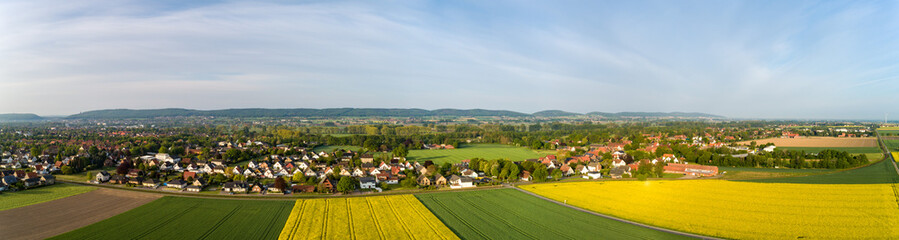 Fototapeta na wymiar Luftaufnahme von Feldern mit einer Kleinstadt im Hintergrund