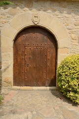 Fototapeta na wymiar Wooden door under stone arch in Girona village