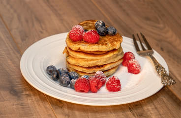 Fresh pancakes with berries on the wood table