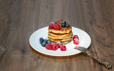 Pancakes with berries on the wood table