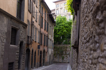 Fototapeta na wymiar Traditional narrow Italian street and no people in Bergamo historical center, Italy. Medieval buildings. There's no one on the street.