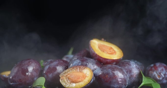 Ripe plum with leaves and cool steam.