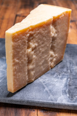 Big wedge of parmigiano-reggiano parmesan hard Italian cheese made from cow milk or Grana Padano