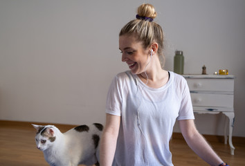 Young girl happy to be listening to music with her cat after exercising