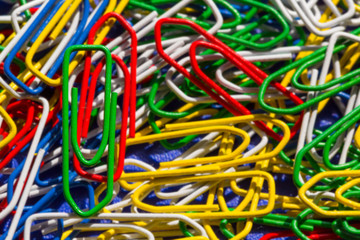 Close up one green paper clip in colorful paper clips, background - 348249791
