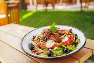 fried meat with mixed mediterranean salad olives radish sunflower seed lettuce