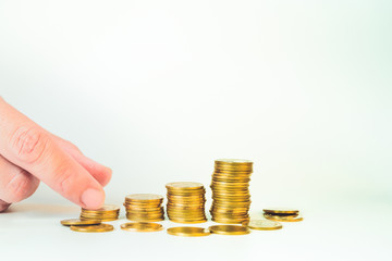 business and finance investment and saving activity with gold coin arrange on white isolated with finger acting background