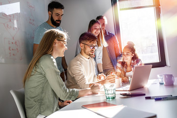 Group of programmers and designers in a conference room. They're discussing development of a new project.	