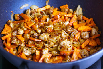 Sliced onions and carrots and pan-fried meat, background, cooking a traditional Eastern dish pilaf
