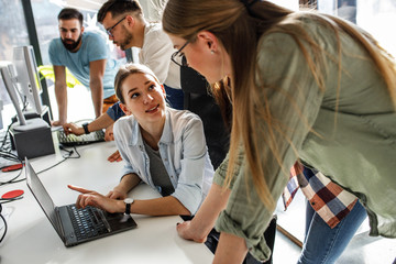 Group of team workers and programmers starting a new project.Senior programmer helps a beginner.