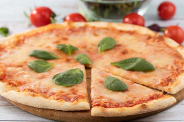 pizza with cheese sauce and spinach on wooden background