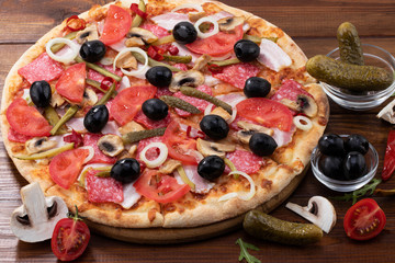 pizza with with pepperoni and olives on wooden background