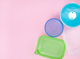 different plastic food containers on a colored background. top view on green, blue, cyan, white food boxes