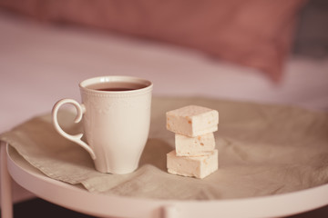 Cup of tea with sweet candy on table in room. Good morning. Breakfast time.