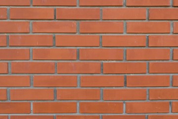 Orange background with grey geometric patterns. Red wall of rectangular stones, bricks, tile. Brickwork