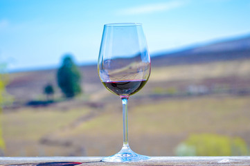 SIngle red wine glass with blurry background.
