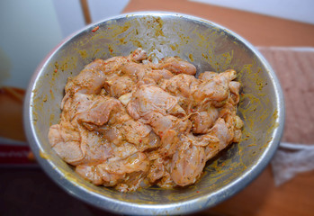 Seasoned chicken wings in a metal bowl.
