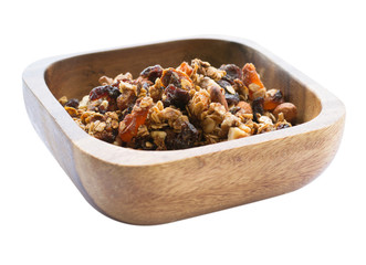 Morning breakfast with granola in a wooden bowl isolated on white background. Side view.