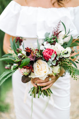 Close-up bouquet of flowers in women's hands. style, floral arranging, wedding concept.