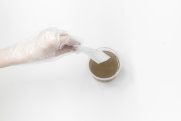 Close up of medical experiments. transparent jar, three pockets with reagents, medical gloves on isolated light background. Experiments for kids. Selective focus