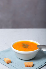 Pumpkin and carrot soup with fresh dill on table