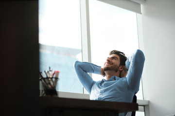 Happy Business Man With Hands Behind Head Leaning On Chair