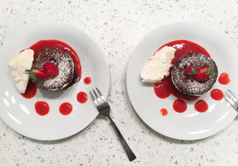 Homemade chocolate fondant lava cake with strawberries served with vanilla ice cream, strawberry...