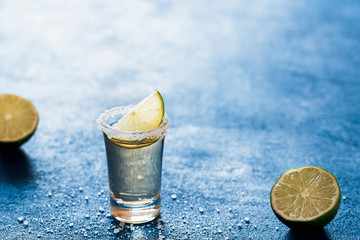 Shot of tequila with salt and lime. Single glass of mexican drink