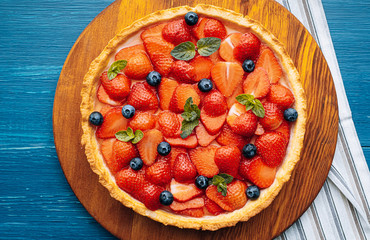 strawberry custard pie with lime zest added to which are sliced strawberries with blueberries and...