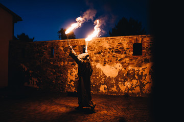 photo of a fire show performer playing with fire