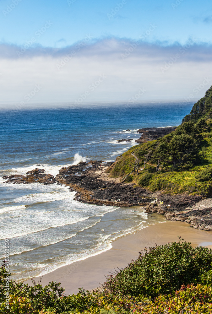 Wall mural vertical image - waves crashing on the rocky coast in oregon with wall of fog offshore.