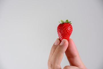 Fresh organic strawberries in mans hand.