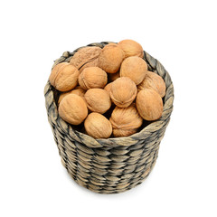 wicker basket with walnuts isolated on a white background.