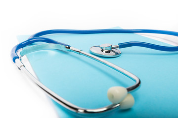 medical record and blue stethoscope close-up on white background